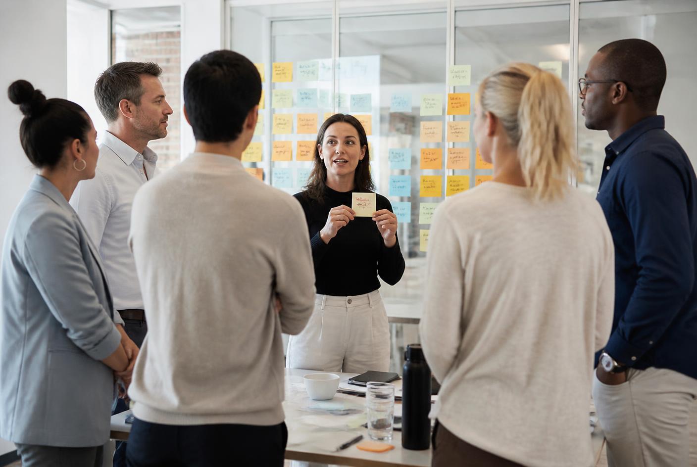 Facilitator houdt een kaart omhoog tijdens een sessie met een marketing- en salesteam