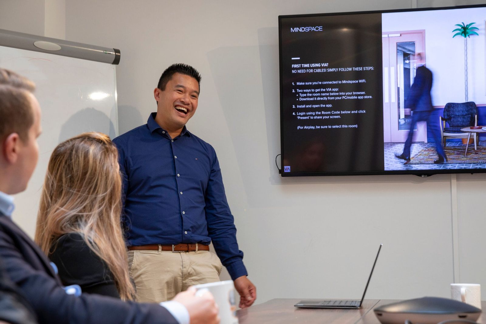 Wing Cheung presenteert aan een team in een vergaderruimte